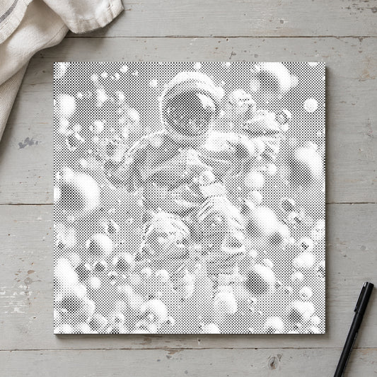 Toile de peinture par points “Astronaute abstrait”, vue du dessus sur une table de travail à la lumière douce du jour.