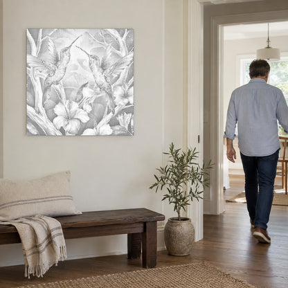 Toile de peinture par points “Colibris parmi les fleurs”, sur un mur clair, avec une personne passant par la porte voisine.
