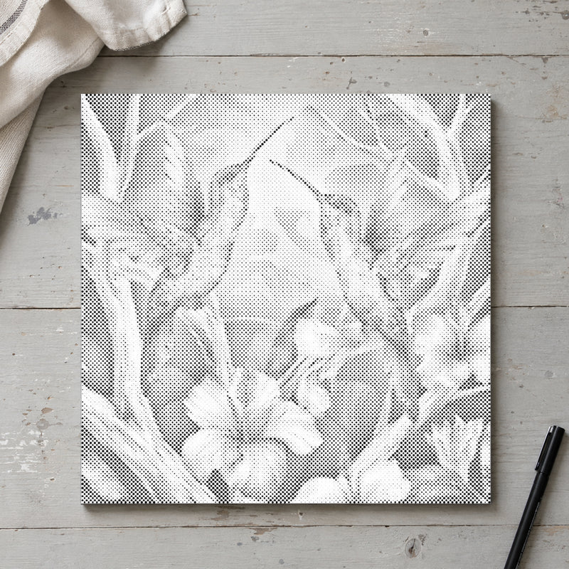 Toile de peinture par points “Colibris parmi les fleurs”, vue du dessus sur une table de travail à la lumière douce du jour.