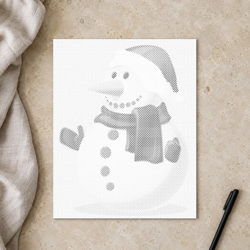 Toile de peinture par points “Bonhomme de neige”, vue du dessus sur une table de travail à la lumière douce du jour.